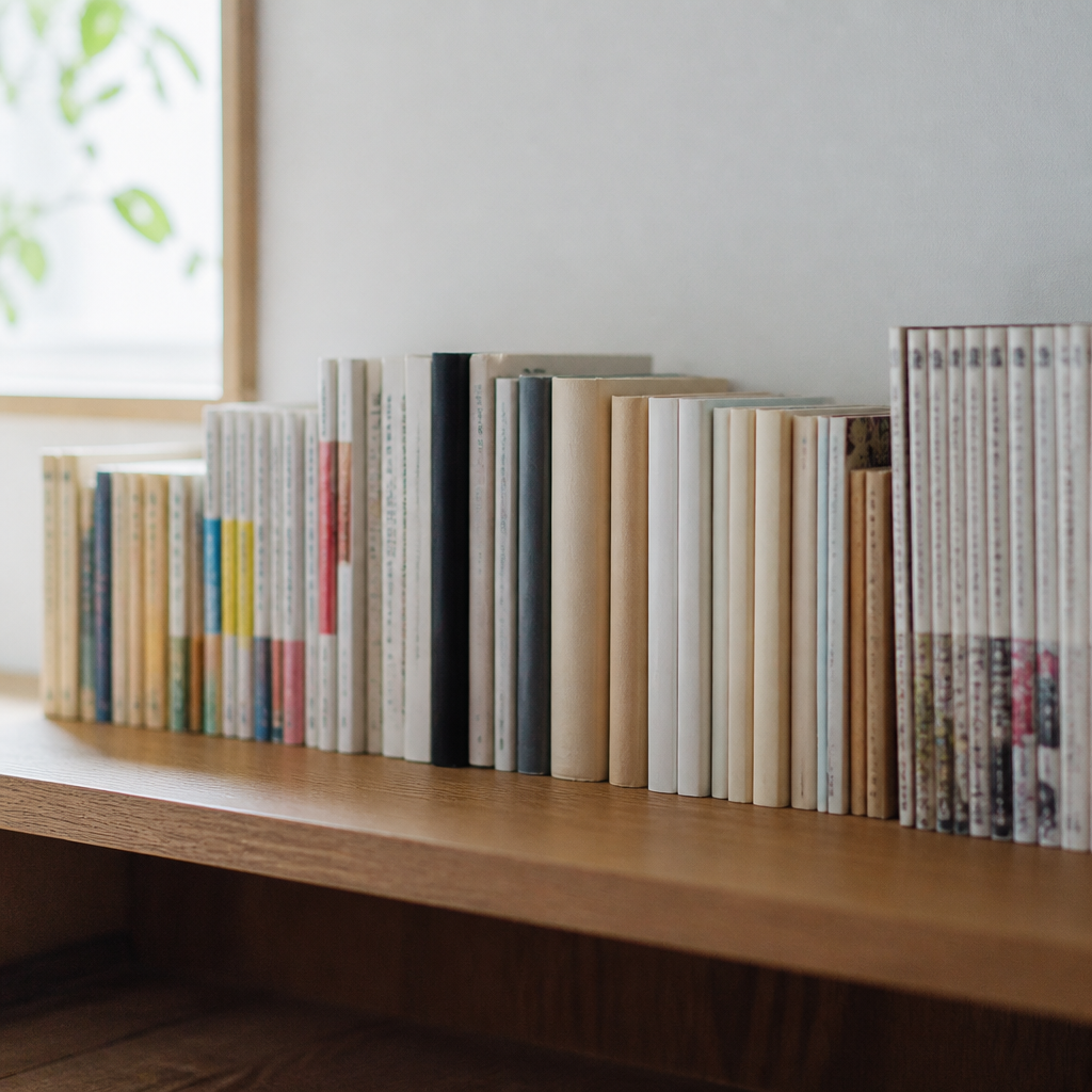 書棚を横から見た一列。文庫、新書、四六判の単行本、随筆集、漫画の単行本が五つのかたまりに分かれて並んでいる